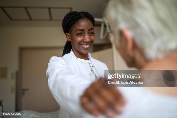 doctor comforting her senior patient in the hospital room - patient hospital selective focus stock pictures, royalty-free photos & images