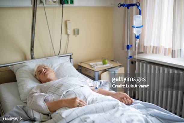senior patient lying in hospital bed after surgery - lying on back stock pictures, royalty-free photos & images