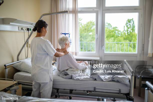physio therapist giving massage to senior patient - verpleegkundig assistent stockfoto's en -beelden