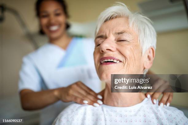 elderly patient getting a massage in rehab - relief emotion fotografías e imágenes de stock