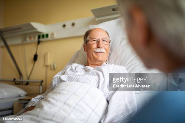 sick man talking with visiting wife in hospital room - promises rehab center foto e immagini stock