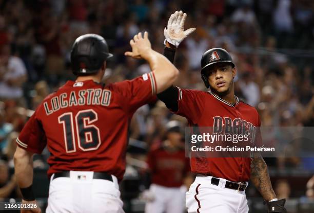 Ketel Marte of the Arizona Diamondbacks high fives Tim Locastro after both scored runs against the Washington Nationals during seventh inning of the...