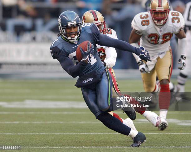 Seattle Seahawks receiver Peter Warrick heads up field pursued by Bruce Thornton of the San Francisco 49ers during 41-3 victory at Qwest Field in...