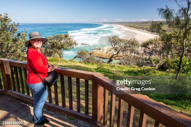 senior woman enjoying the view of main beach on north stradbroke island, qld, australia - queensland rail stock pictures, royalty-free photos & images