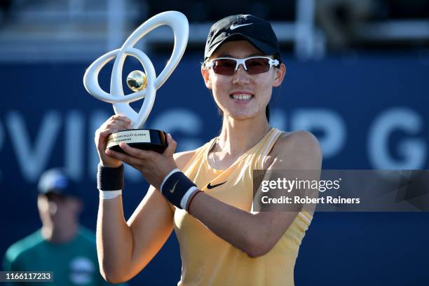 Saisai Zheng of China celebrates with the winner's trophy after defeating Aryna Sabalenka of Belarus in the singles final of the Mubadala Silicon...