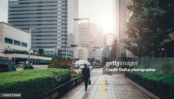 young businessman walking in tokyo shinjuku - shinjuku bezirk stock-fotos und bilder