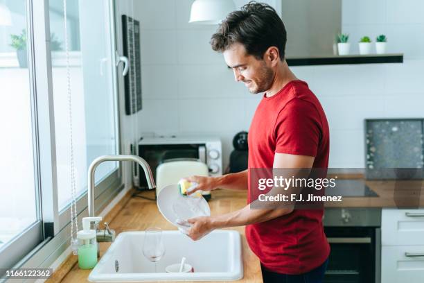 man washing dishes in the sink - afwas doen stockfoto's en -beelden