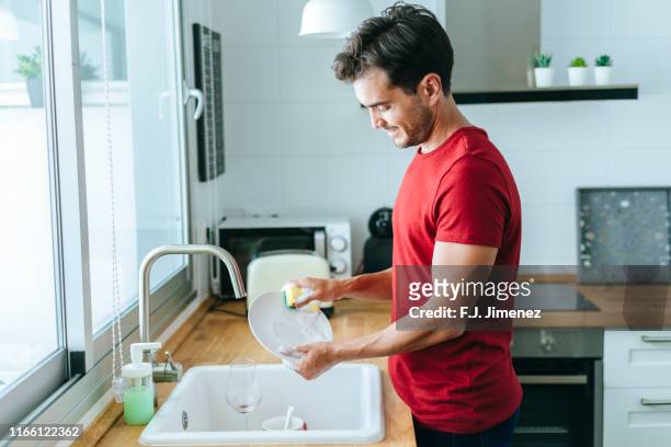 man washing dishes in the sink - washing dishes stock pictures, royalty-free photos & images