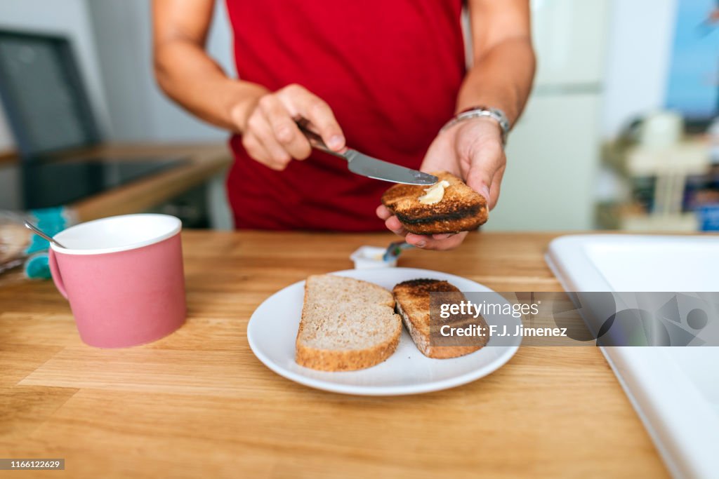 Man smearing butter on toast