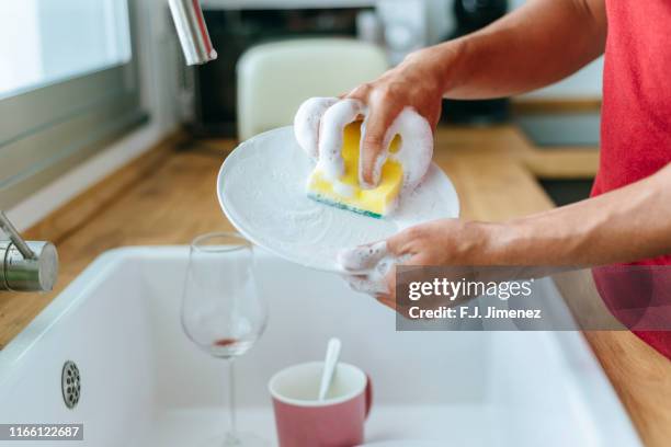 close-up of man washing dishes in the sink - vaisselle photos et images de collection