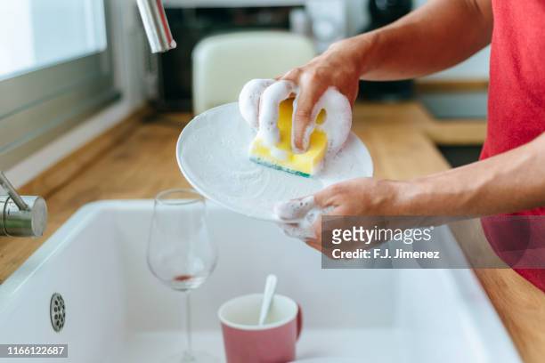 close-up of man washing dishes in the sink - afwas doen stockfoto's en -beelden