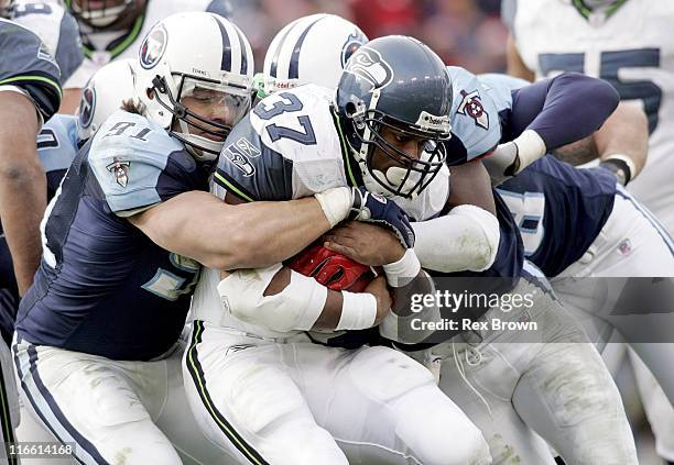 Tennessee's Travis LaBoy and teammate Keith Bulluck wrap up Seattle's Shaun Alexander during the second half December 18 at the Coliseum, in...