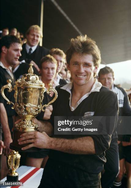 David Kirk, captain of the New Zealand All Blacks, holding the Webb Ellis trophy after winning the inaugural Rugby Union World Cup Final against...