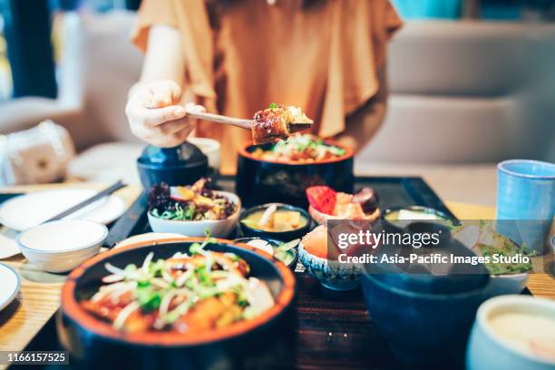 young asian woman enjoying japanese food-eel rice. - japanese food stock pictures, royalty-free photos & images