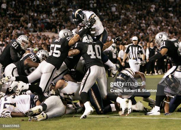 San Diego runningback LaDainian Tomlinson goes up high for the first touchdown of the game as the San Diego Chargers defeated the Oakland Raiders by...