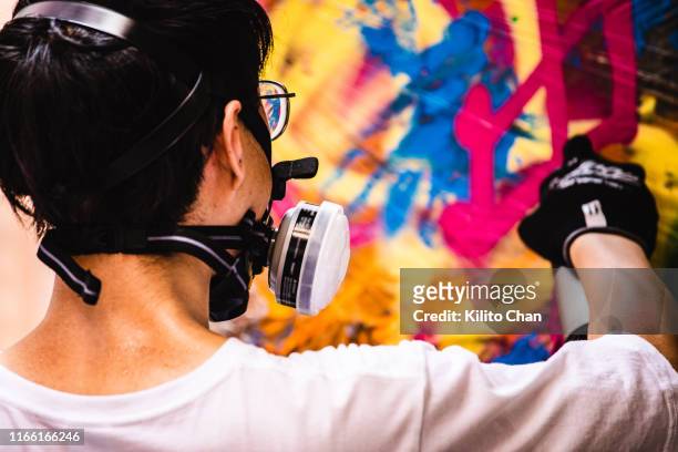 street artist making a spray graffiti on the wall - street artist stock pictures, royalty-free photos & images