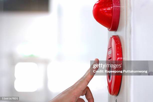 hand pulling fire alarm on the wall - sinal de emergência equipamento de segurança - fotografias e filmes do acervo