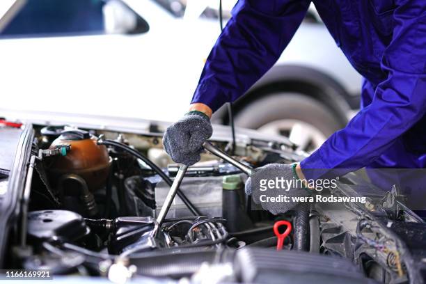 auto mechanic using repair tools check car in garage - car repairs stock-fotos und bilder