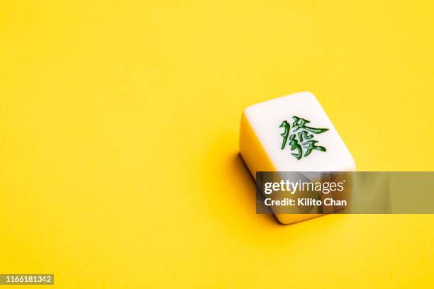 chinese mahjong tile against yellow background - spelregels stockfoto's en -beelden