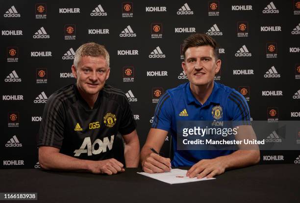 Harry Maguire of Manchester United poses with Manager Ole Gunnar Solskjaer after signing for the club at Aon Training Complex on August 04, 2019 in...