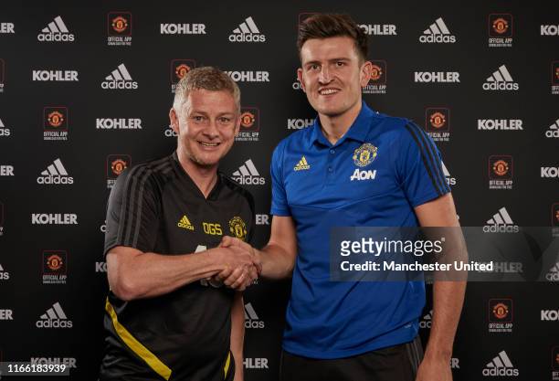 Harry Maguire of Manchester United poses with Manager Ole Gunnar Solskjaer after signing for the club at Aon Training Complex on August 04, 2019 in...