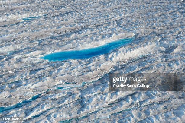 In this view from an airplane a lake of meltwater forms on the Greenland ice sheet near Sermeq Avangnardleq glacier on August 04, 2019 near...