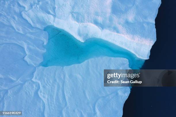 In this aerial view meltwater forms a pond on an iceberg in the Ilulissat Icefjord on August 04, 2019 near Ilulissat, Greenland. The Sahara heat wave...