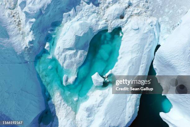 In this aerial view meltwater forms a lake on an iceberg in the Ilulissat Icefjord on August 04, 2019 near Ilulissat, Greenland. The Sahara heat wave...