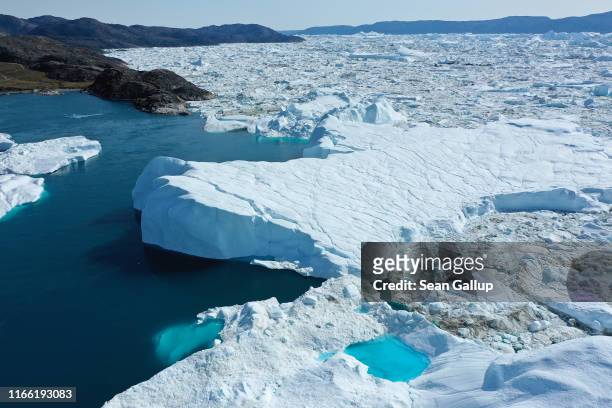 In this aerial view icebergs and ice float jammed into the Ilulissat Icefjord on August 04, 2019 near Ilulissat, Greenland. The Sahara heat wave that...