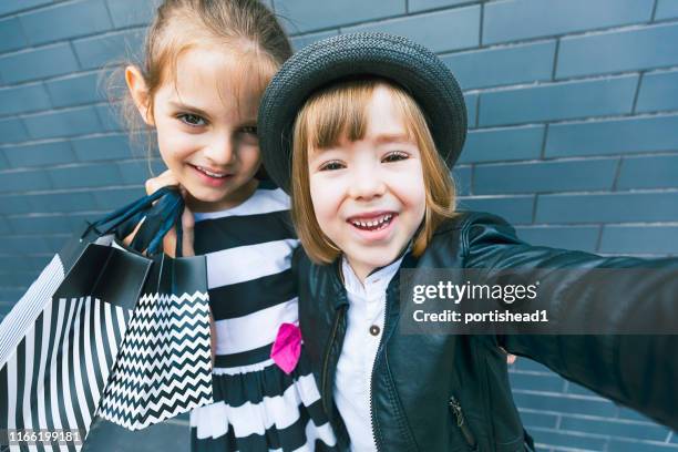 happy children with shopping bags taking selfie - silver spoon in mouth stock pictures, royalty-free photos & images