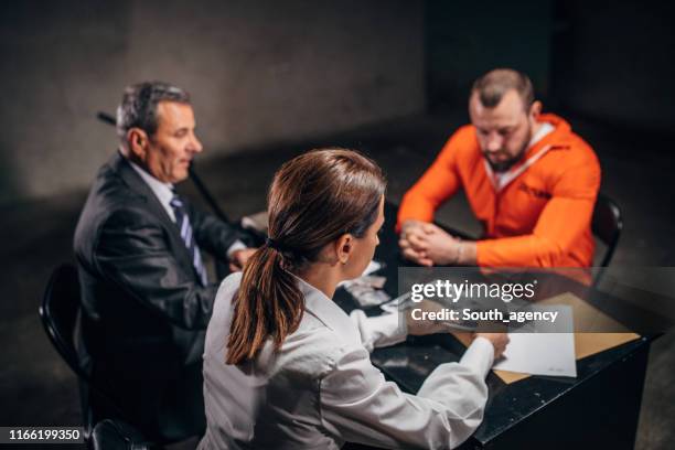 detectives interrogating a male prisoner - prosecuting attorney stock pictures, royalty-free photos & images