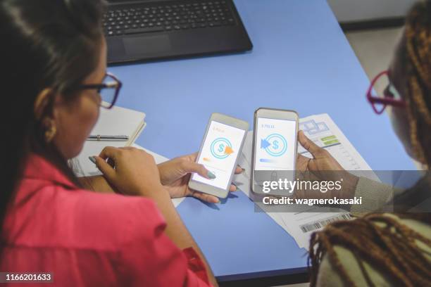 young women sending money through digital wallet, using wireless technology - sending payment stock pictures, royalty-free photos & images