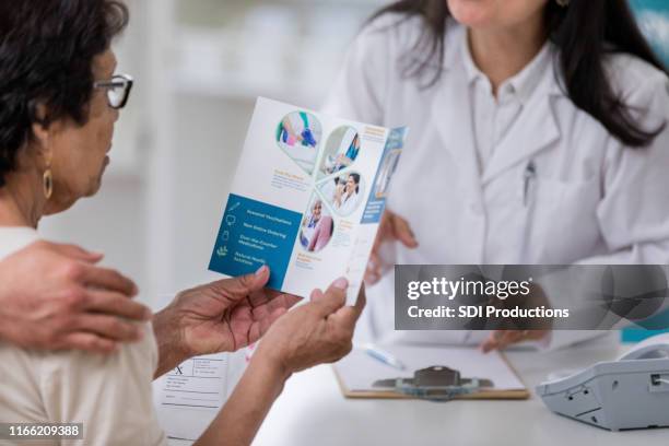 senior woman examines pharmacy brochure - flyer leaflet stock pictures, royalty-free photos & images