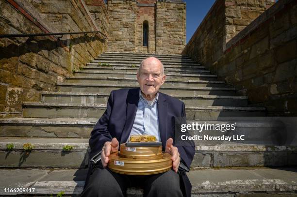Ed Hawkins outside the Jones Beach East Bathhouse in Wantagh, New York, on July 24, 2019. Hawkins holds some of the film shot by his uncle showing...