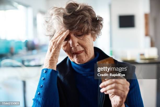 worried senior woman with credit card and computer - regret shopping stock pictures, royalty-free photos & images