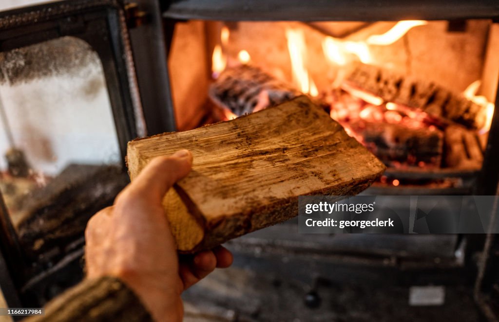 Putting a log into a wood burning stove