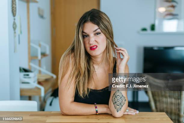 portrait of woman with angry face in home's living room - offensive stockfoto's en -beelden