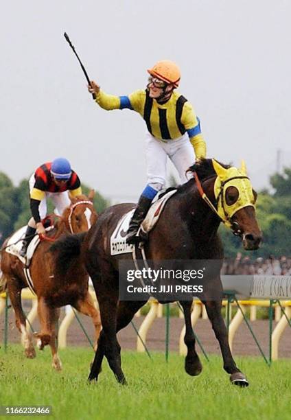 Italian jockey Mirco Demuro reacts on the back of Neo Universe as they won the 70th Japan Derby horse race at the Tokyo racecourse 01 June 2003....