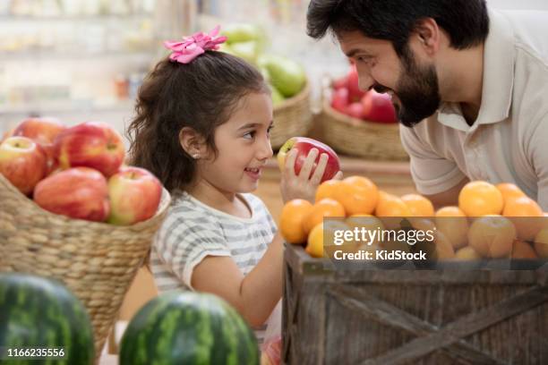 father and daughter buying fruits at supermarket - pick tooth bildbanksfoton och bilder