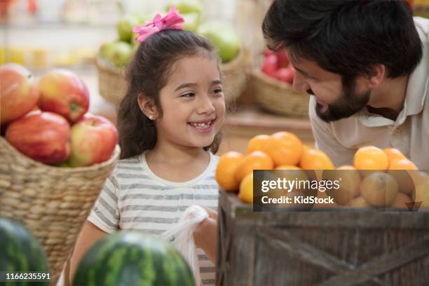 father and daughter buying fruits at supermarket - kidstock girl stock pictures, royalty-free photos & images