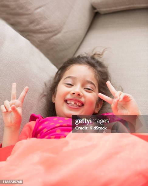 hispanic girl laying on the sofa - kidstock girl stock pictures, royalty-free photos & images