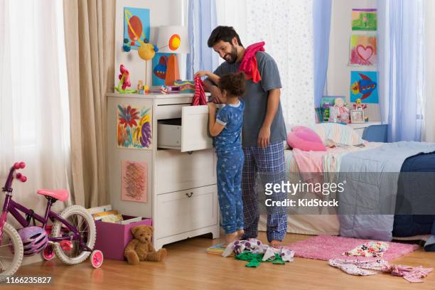father helping daughter to choose clothes - kidstock girl stock pictures, royalty-free photos & images