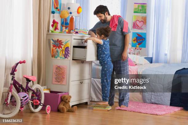 father helping daughter to choose clothes - kidstock girl stock pictures, royalty-free photos & images