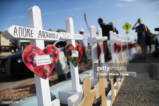 Handmade crosses memorializing the victims of a mass shooting, which left at least 22 people dead, are lined up before being carried to a nearby...