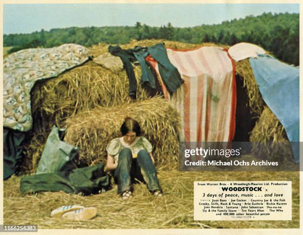 Attendee leans against hay bale at the Woodstock Music Festival on August 16, 1969 in Woodstock, New York.