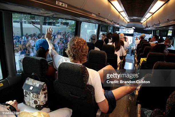 Dirk Nowitzki of the Dallas Mavericks waves to fans as a bus carries the team to the starting point during the Mavericks NBA Champion Victory Parade...