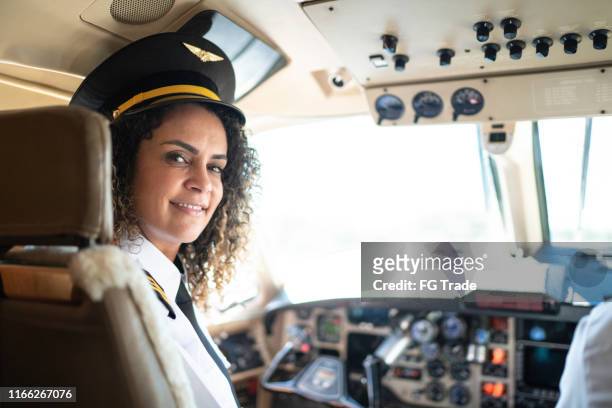 portrait of airplane pilot looking over shoulder in a private jet - airline pilot imagens e fotografias de stock