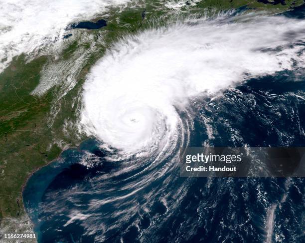 In this NOAA GOES-East satellite handout image, Hurricane Dorian, now a Cat. 1 storm, makes landfall on North Carolina’s Outer Banks at 16:36Z...