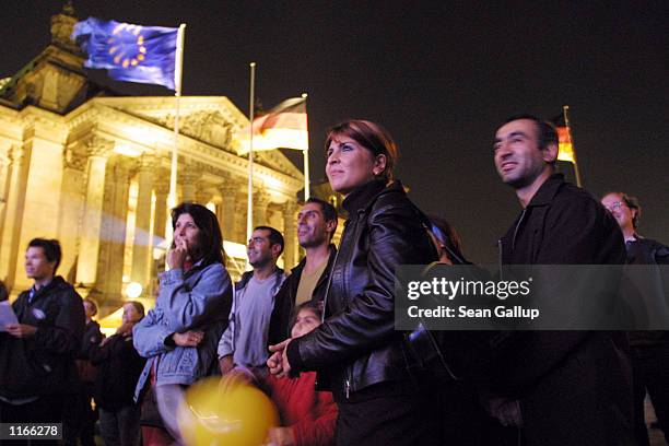 An immigrant family listens to a concert performance in front of the Berlin Reichstag October 2, 2001 on the eve of Germany's Day of Unity, which...