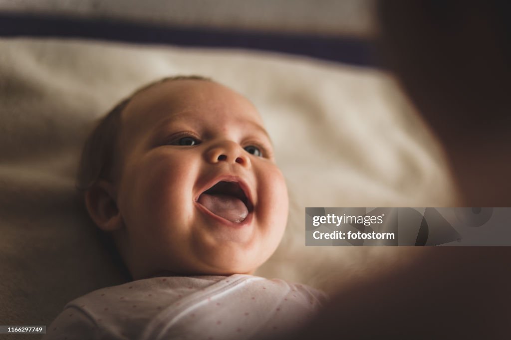 Bebé recién nacido riendo y riendo mientras juega con su madre